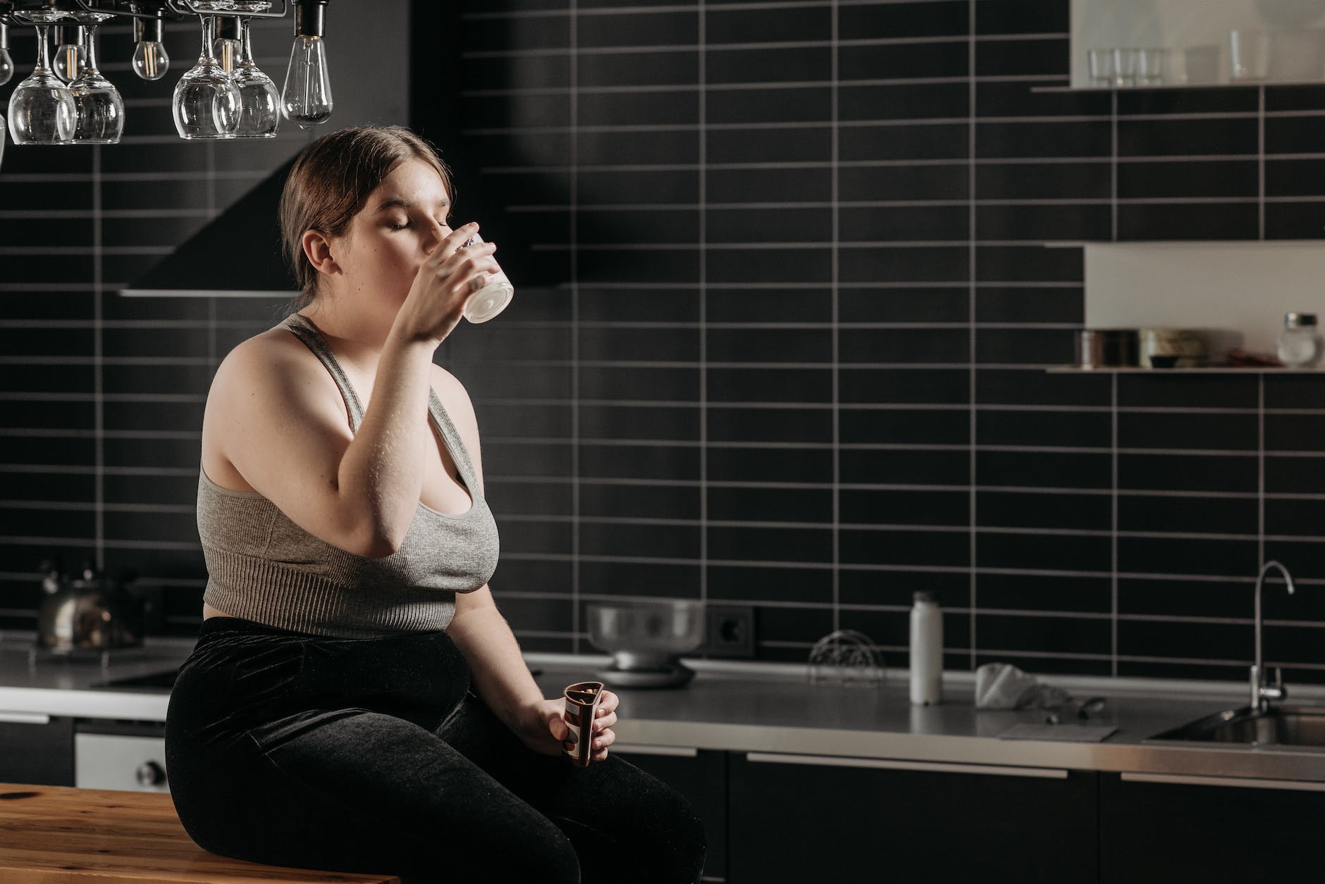 woman sitting on table and drinking milk